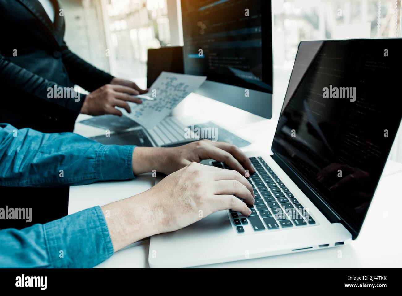 Two partnerships developing programming and coding technologies working on laptop and analyzing together. Stock Photo
