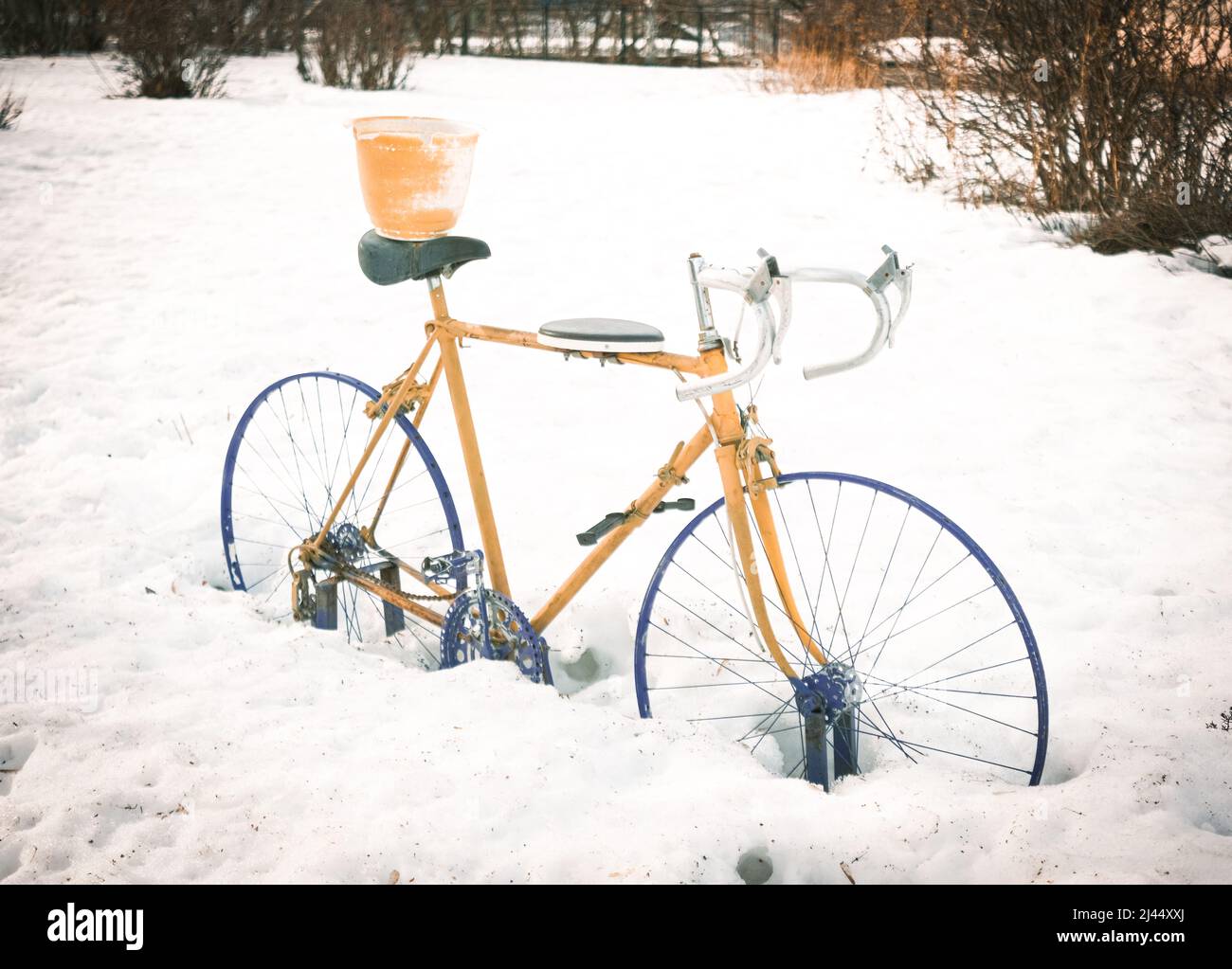 An abandoned sport cycle in the snow colored Stock Photo