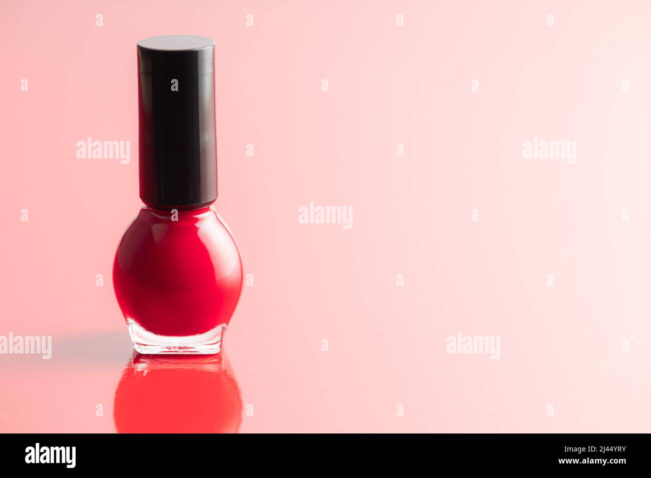 Colorful nail polish bottles on a red background. Stock Photo