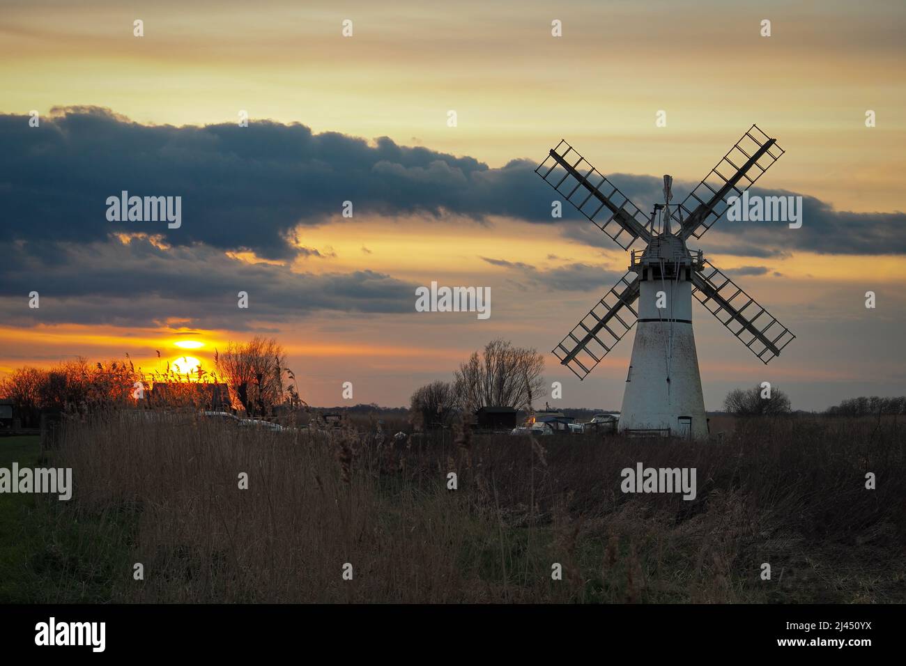 Beautiful orange sunset over Thurne Dyke Drainage Mill in The Broads, Norfolk Stock Photo