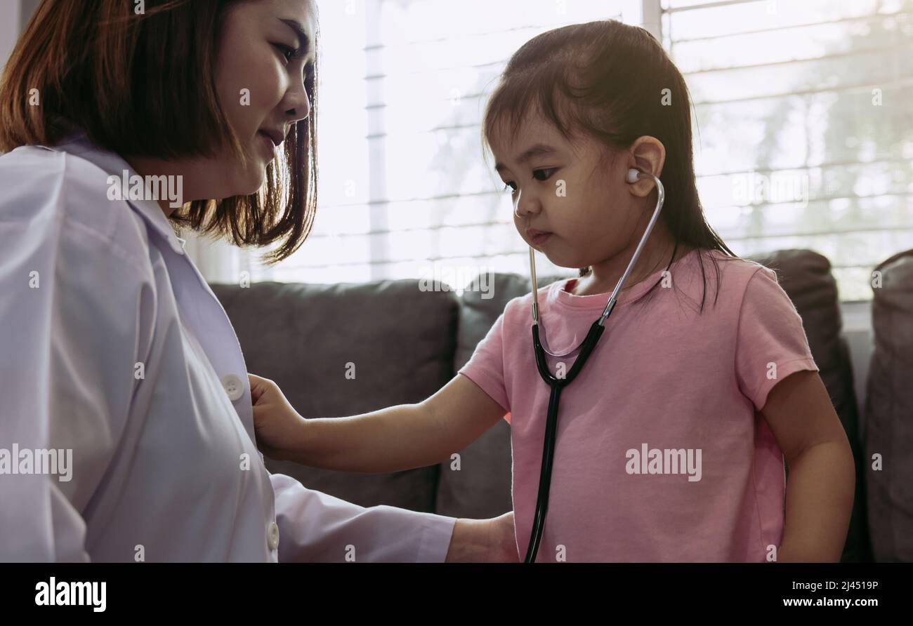 Cute little girl using stethoscope to listen to doctor heartbeat. Stock Photo