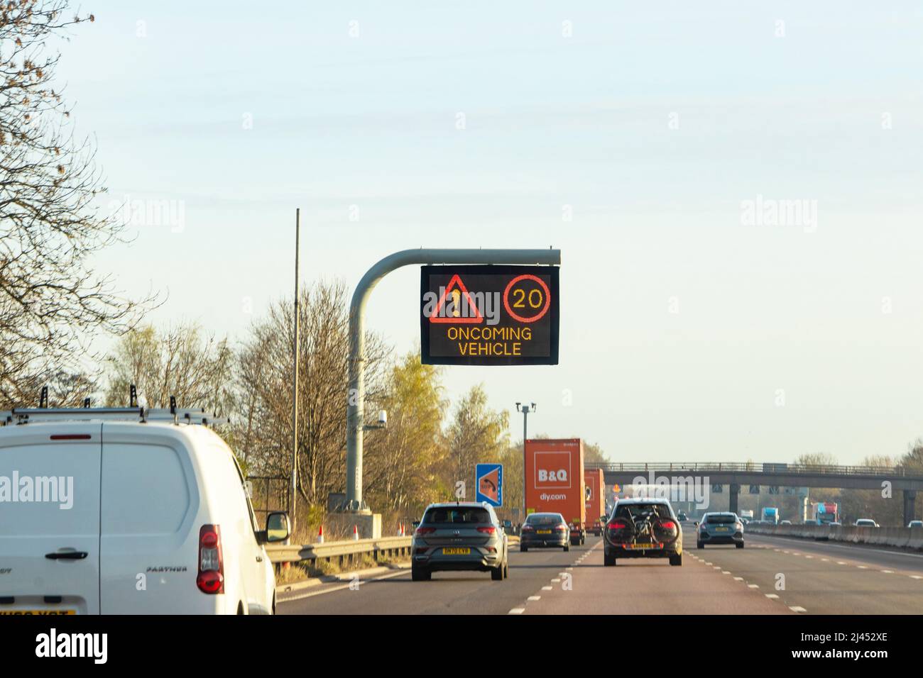 warning matrix sign on gantry with oncoming vehicle and 20 mph sign on M6 uk motorway Stock Photo