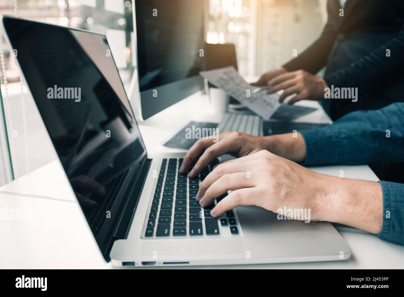 Two partnerships developing programming and coding technologies working on laptop and analyzing together. Stock Photo