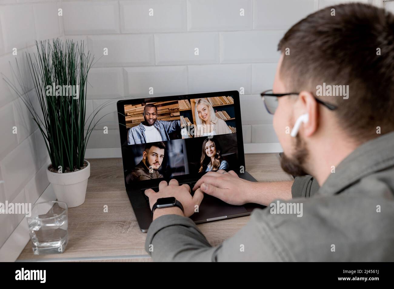 Back view of male employee having an online conference with colleagues ...