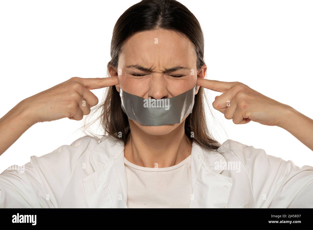 upset young woman with adhesive tape over her mouth blocking her ears