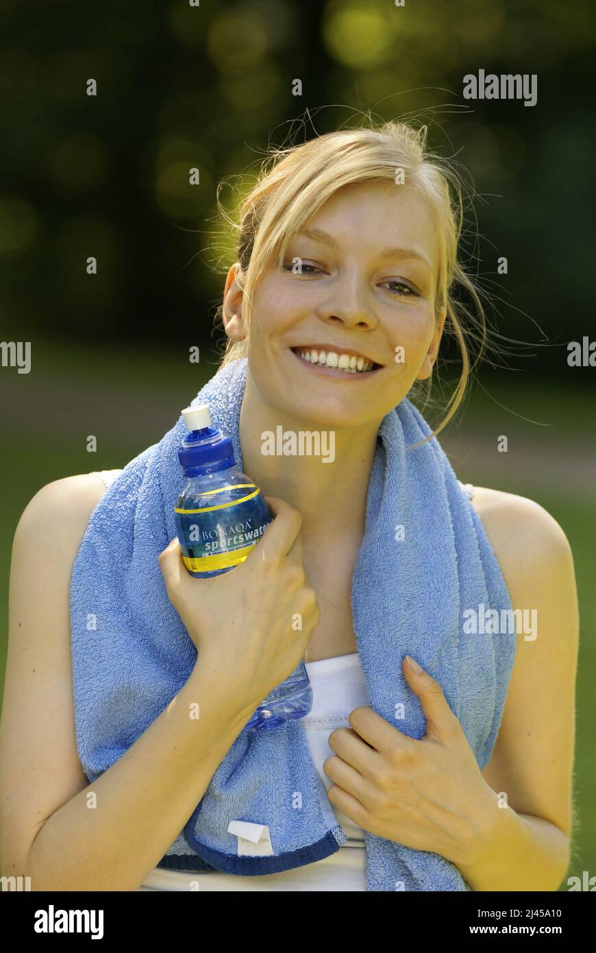 Eine junge Frau trinkt nach dem Sport Mineralwasser,  Hamburg, Handtuch, Sportlerin, Wasser, Wasserflasche, Stock Photo