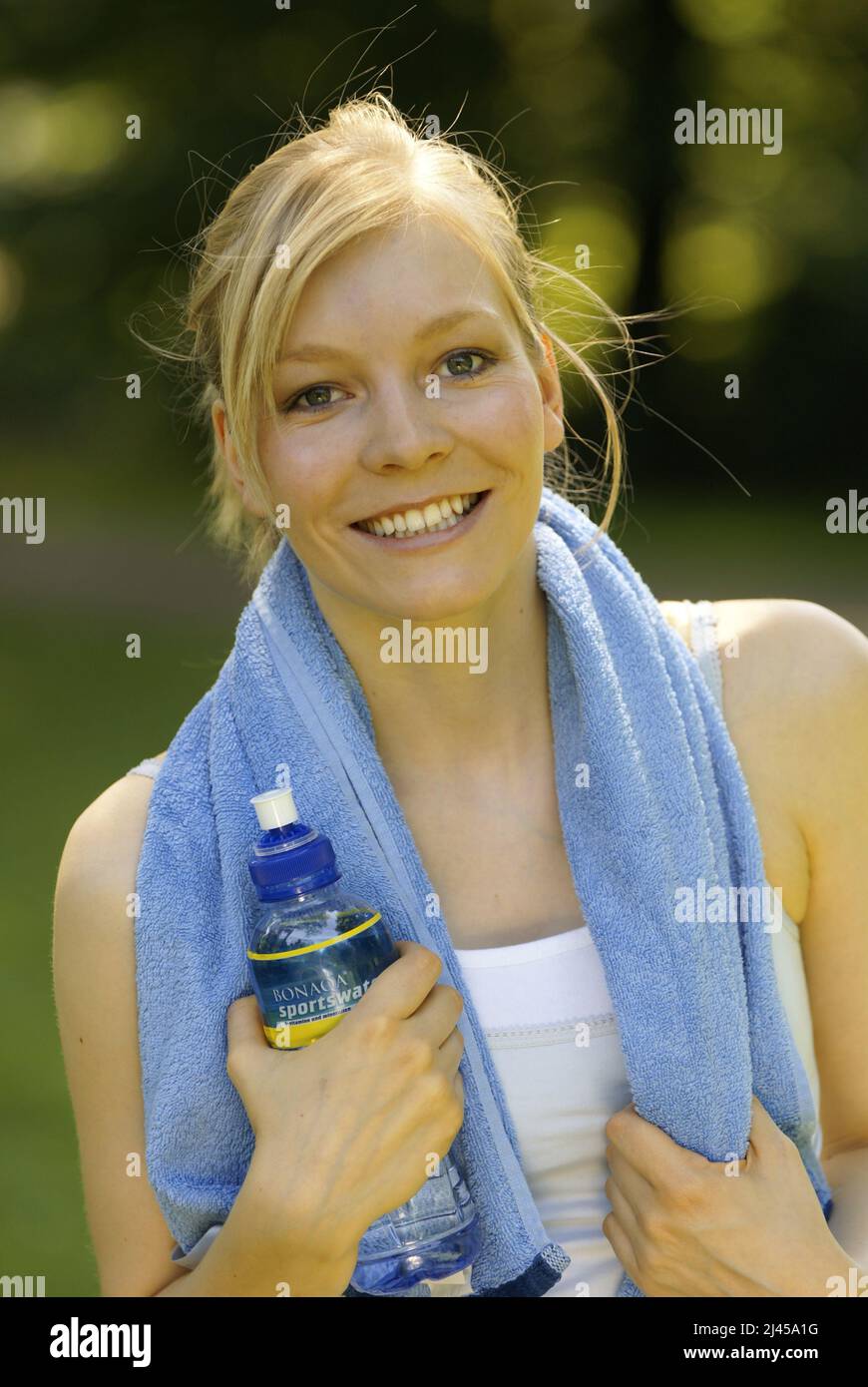 Eine junge Frau trinkt nach dem Sport Mineralwasser,  Hamburg, Handtuch, Sportlerin, Wasser, Wasserflasche, Stock Photo