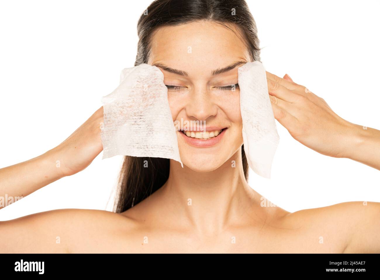 Healthy fresh happy woman removing makeup from her face with wet wipes