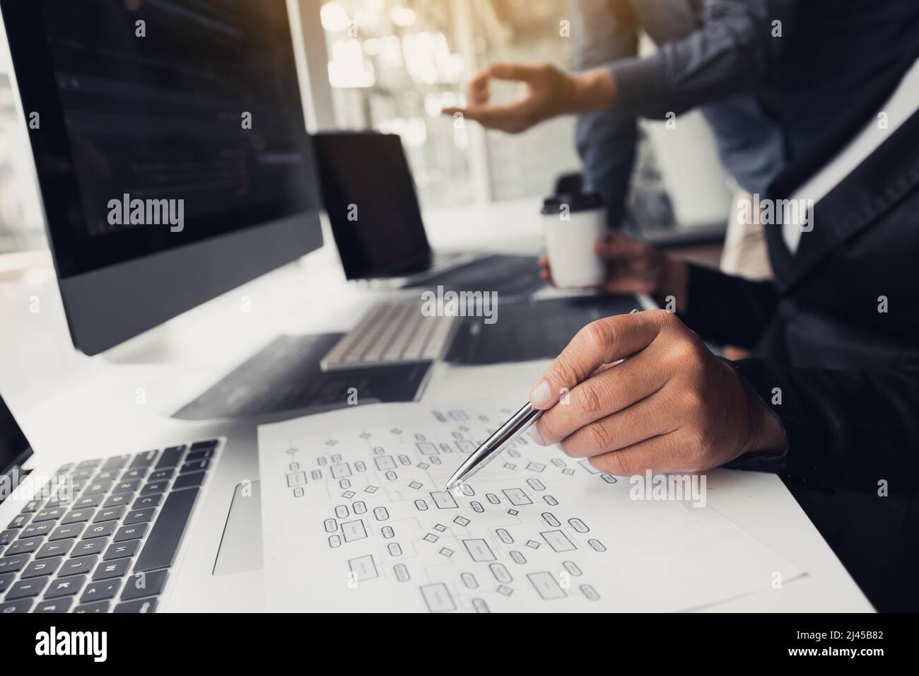 Two partnerships developing programming and coding technologies working on laptop and analyzing together. Stock Photo