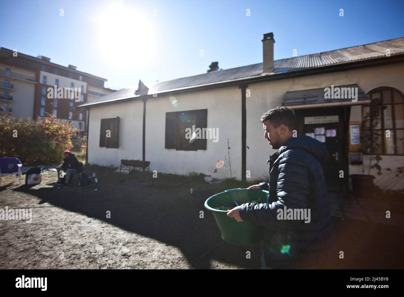 Briancon (French Alps, south-eastern France), November 5, 2021: an exile helps to bring the food that will be distributed for lunch. Reportage at St C Stock Photo