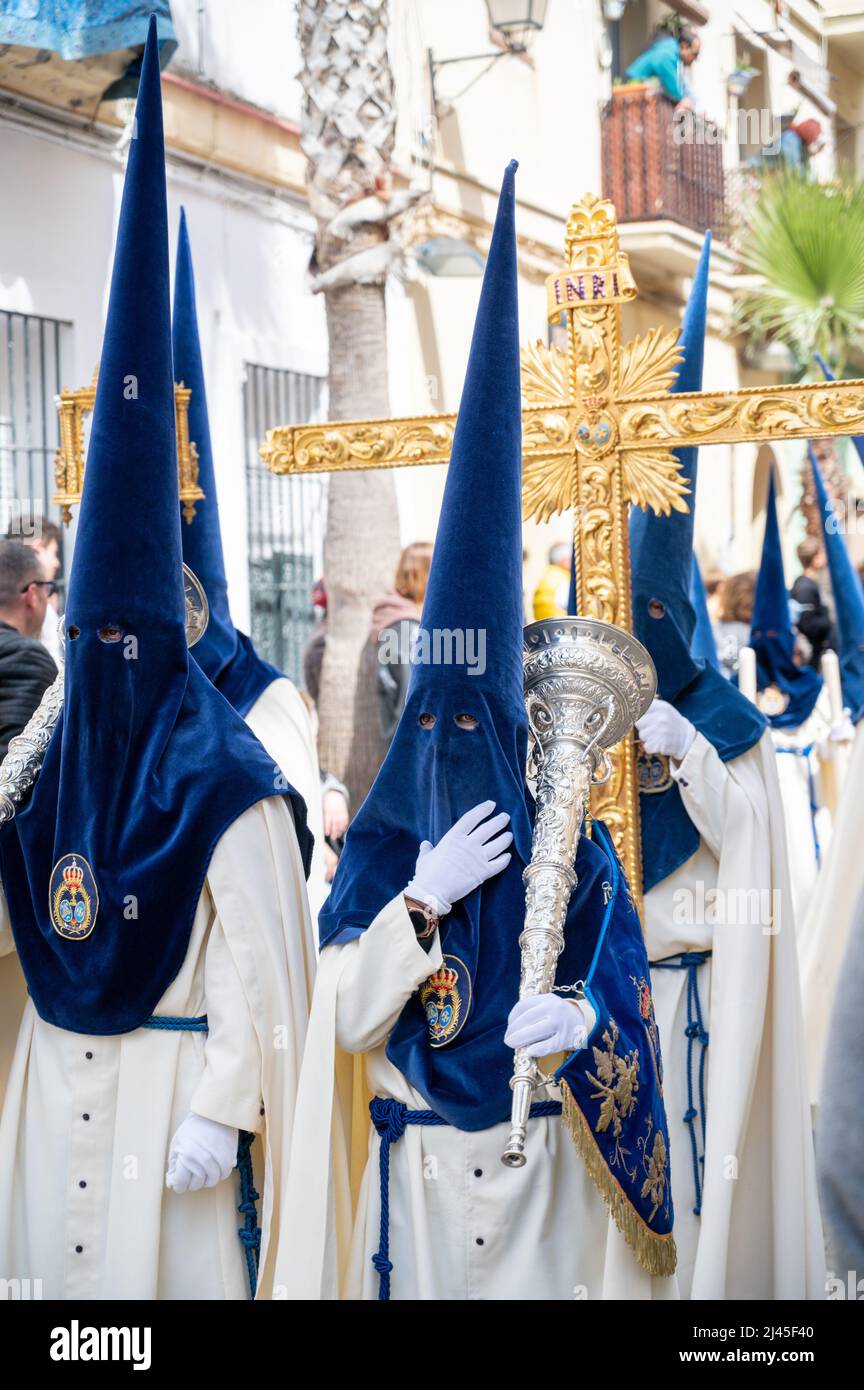 Cadiz, Spain. 11th Apr, 2022. People take part in the traditional Semana Santa or Holy Week parades in Cadiz Spain. Everyday this week the Brotherhoods engage in spectacular processions and marching bands around the city leading huge thrones depicting Jesus on the cross and the Virgin Mary. Many wear traditional robes and high pointed hats. Credit: Julian Eales/Alamy Live News Stock Photo