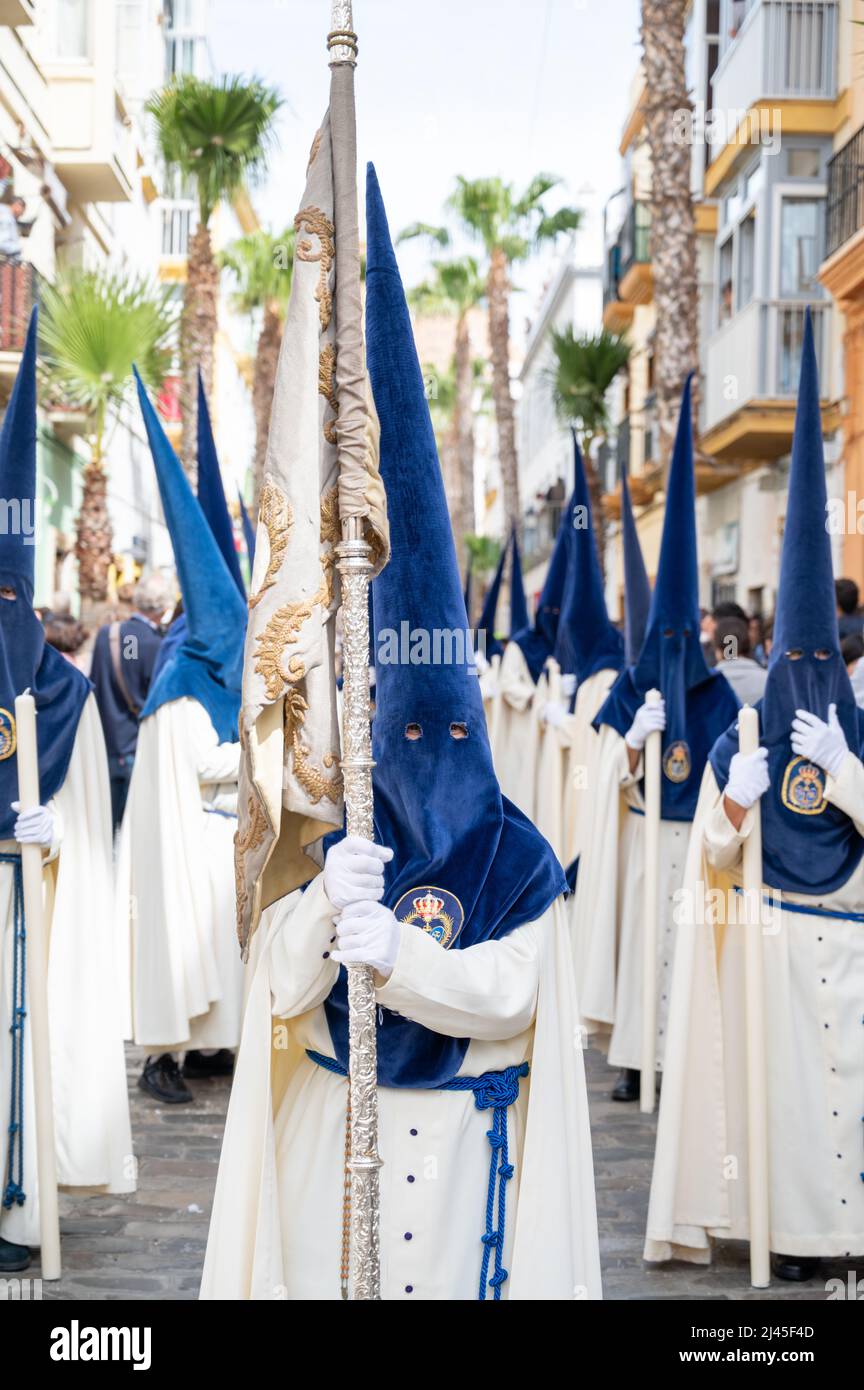 Cadiz, Spain. 11th Apr, 2022. People take part in the traditional Semana Santa or Holy Week parades in Cadiz Spain. Everyday this week the Brotherhoods engage in spectacular processions and marching bands around the city leading huge thrones depicting Jesus on the cross and the Virgin Mary. Many wear traditional robes and high pointed hats. Credit: Julian Eales/Alamy Live News Stock Photo