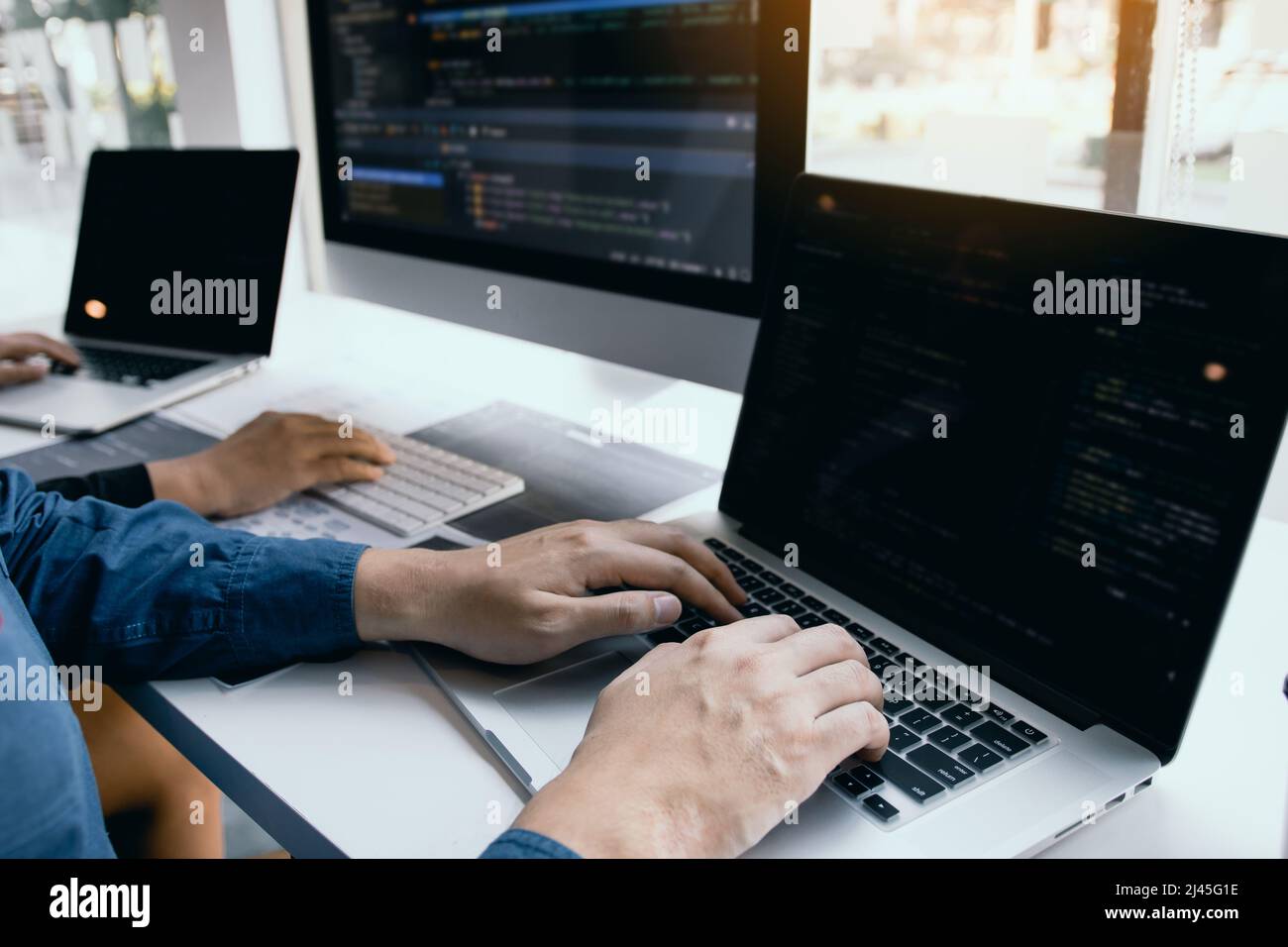 Two software developers are analyzing together about the code written into the program on the computer. Stock Photo
