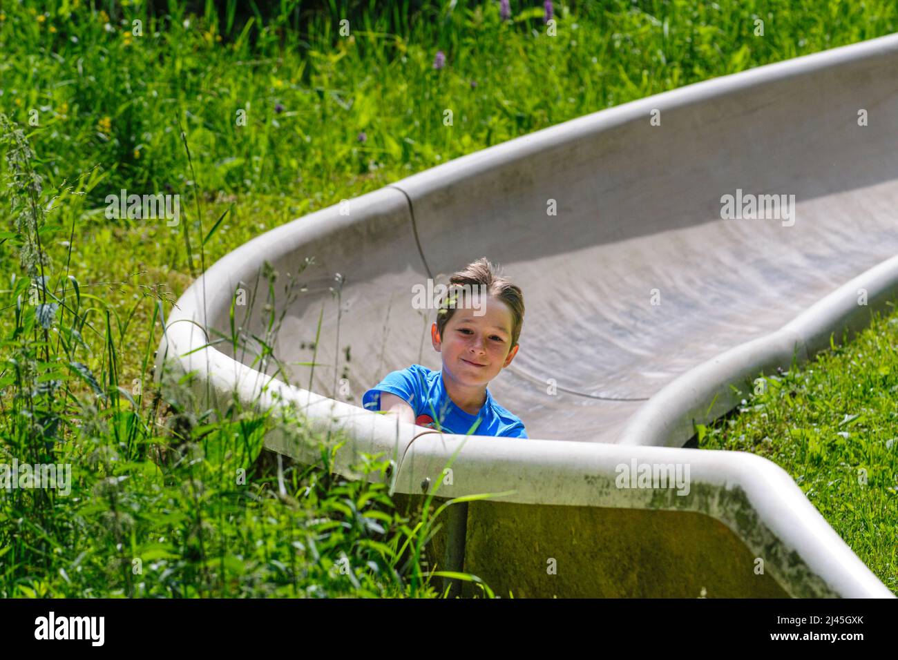 Family fun tobogganing in summer, up with the lift down with the