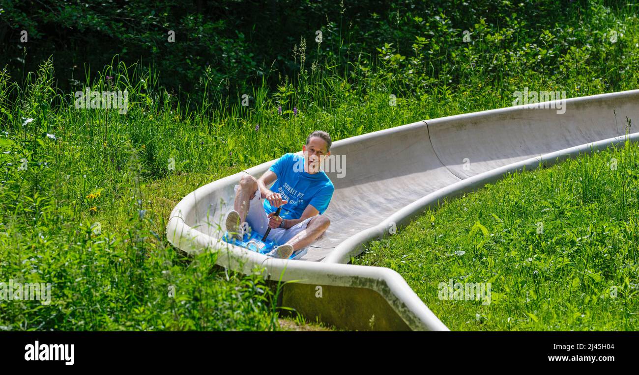 Family fun tobogganing in summer, up with the lift down with the
