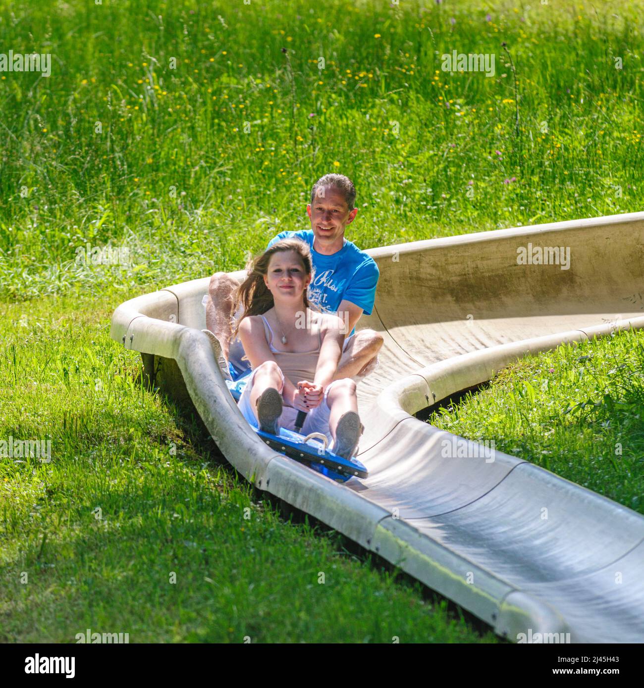 Family fun tobogganing in summer, up with the lift down with the