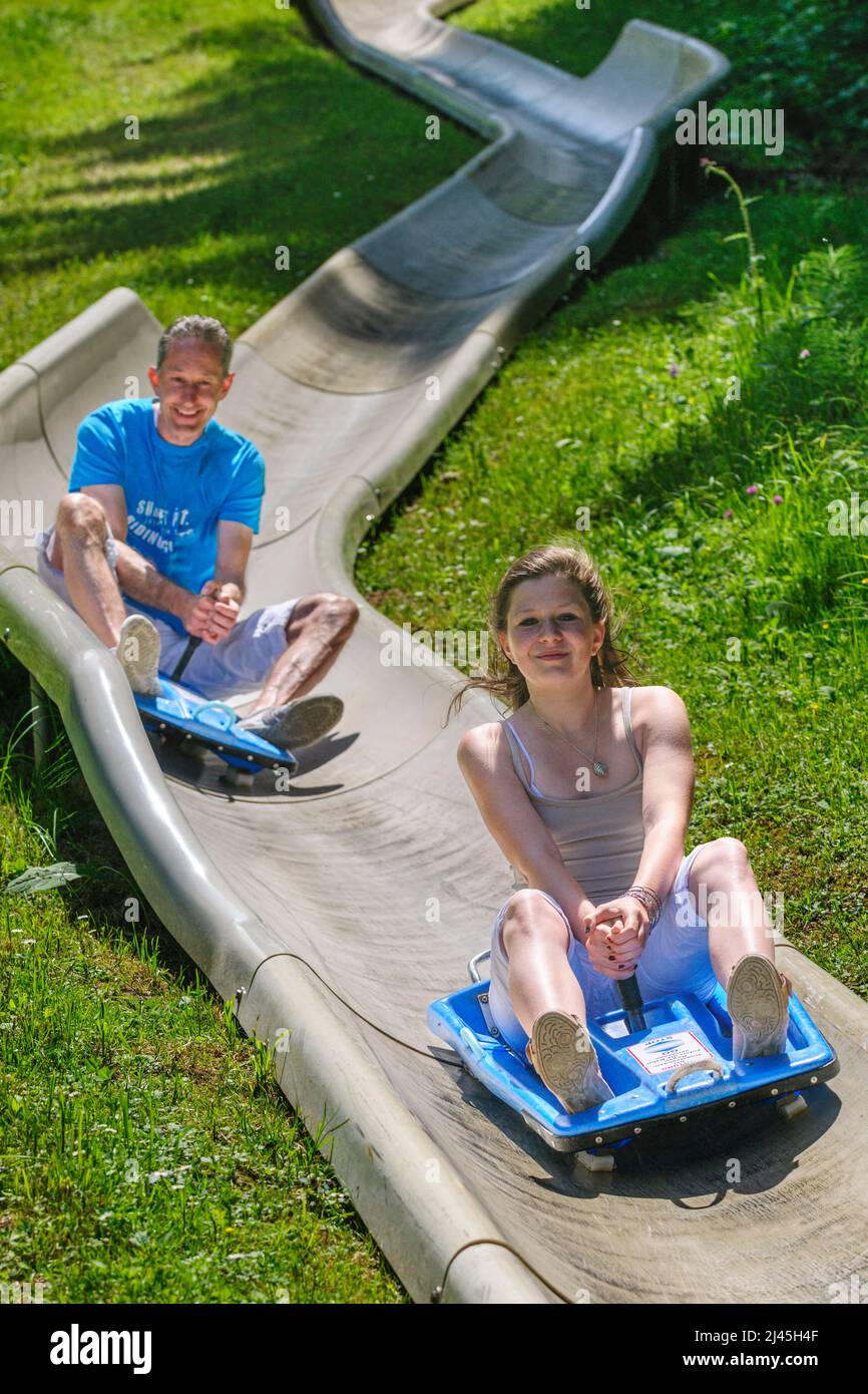 Family fun tobogganing in summer, up with the lift down with the