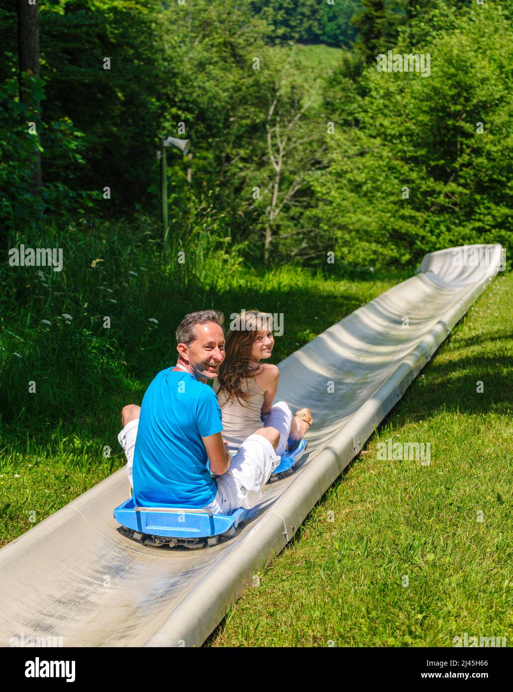Family fun tobogganing in summer, up with the lift down with the