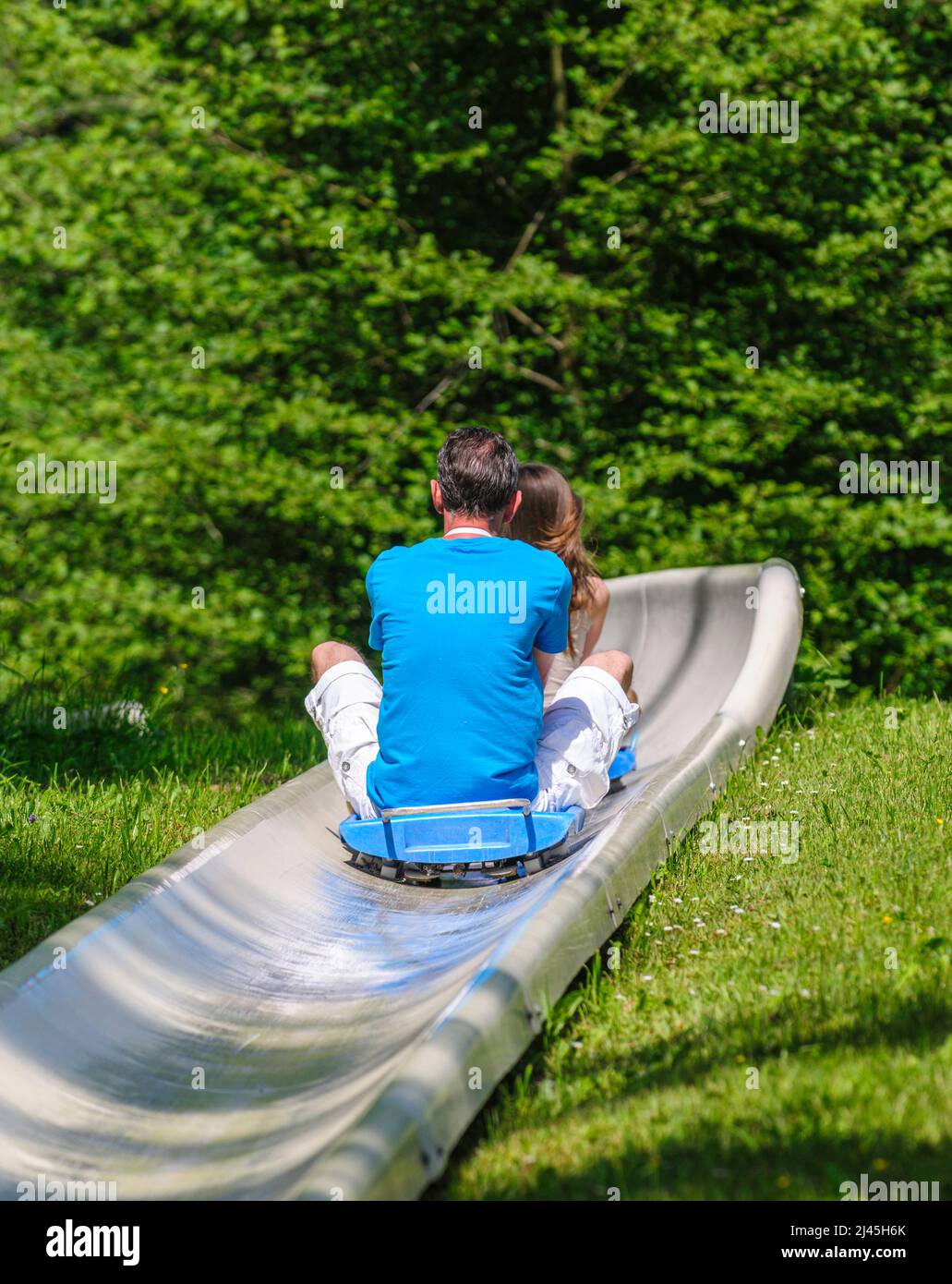 Family fun tobogganing in summer, up with the lift down with the