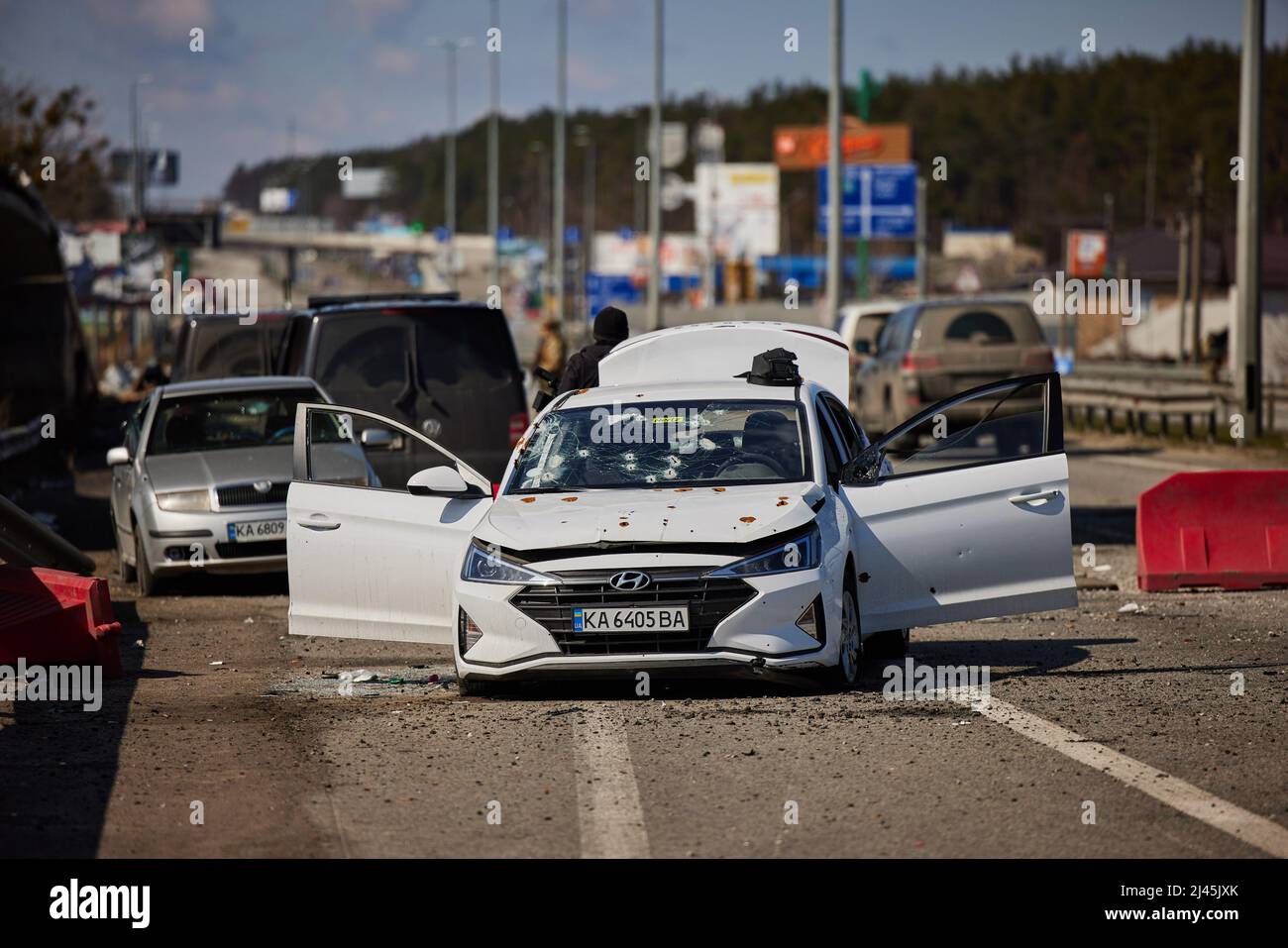 BUCHA, UKRAINE - 04 April 2022 - A car damaged by gunfire on the highway near Bucha, Ukraine. It is not clear from the caption supplied who the occupa Stock Photo