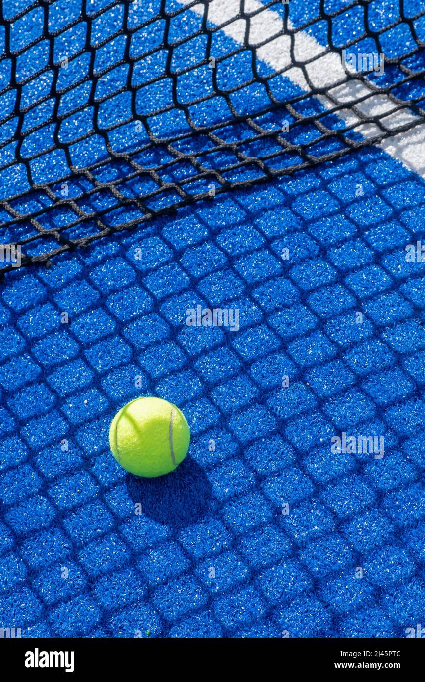 selective focus, paddle tennis ball on a blue paddle tennis court close to the net, racket sports concept Stock Photo