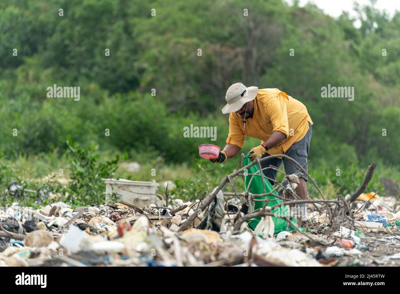 Man picks up plastic garbage on beach in the morning, Panama, Central America. Stock Photo