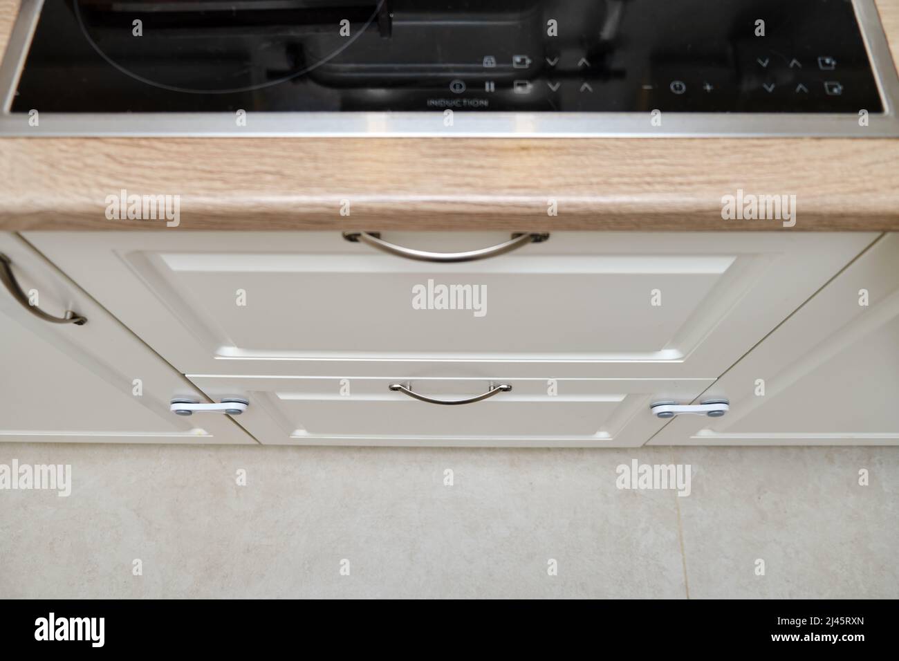 Doors of white kitchen blocked from children. Lock furniture