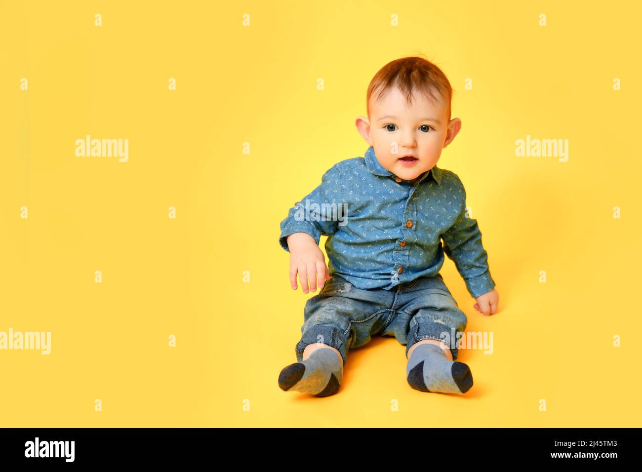 Smiling infant baby boy in jeans 