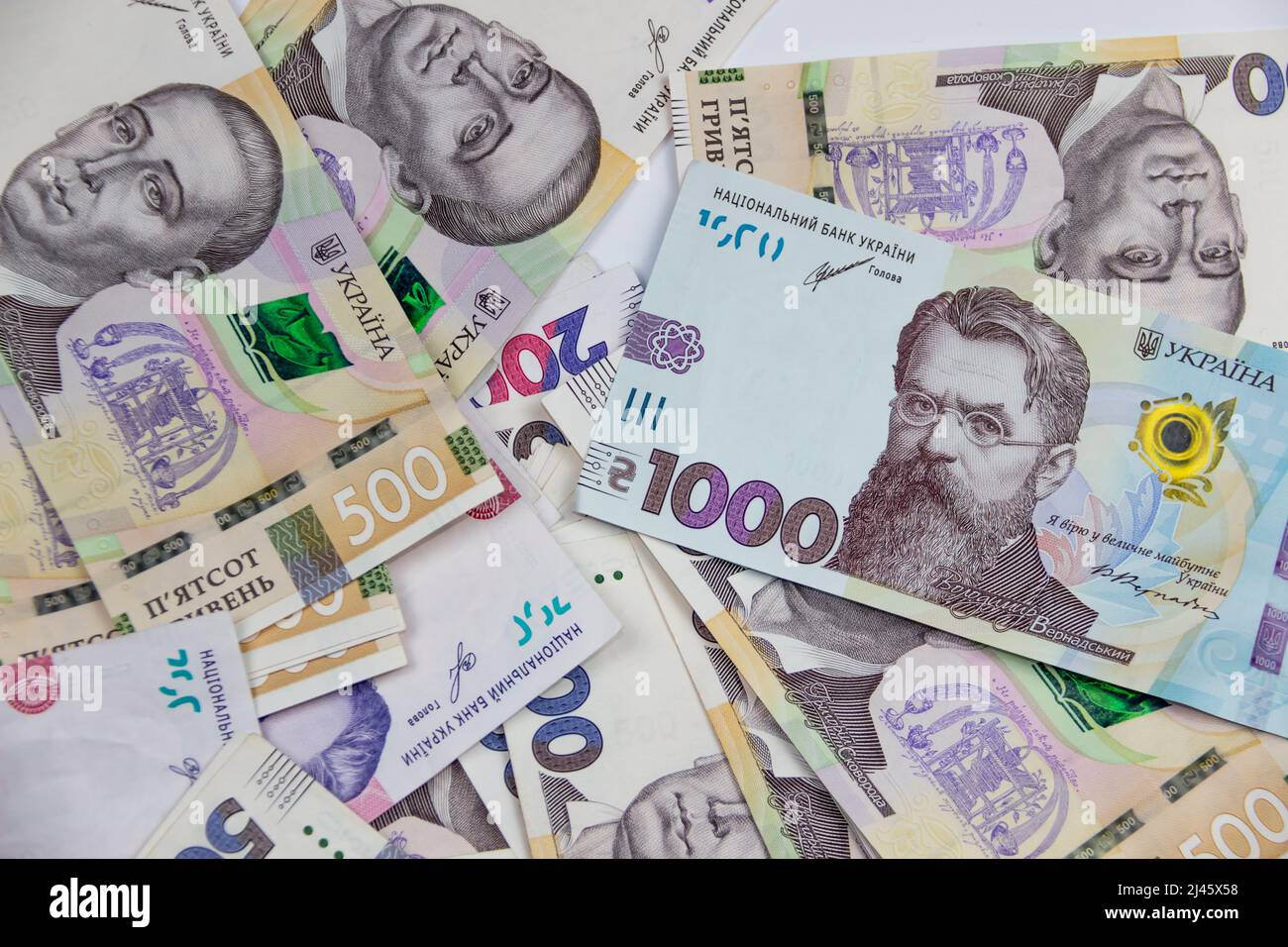 Ukrainian money currency of different denominations scattered. Hryvnia banknotes 200, 500 and 1000 on background. Money of Ukraine. Stock Photo