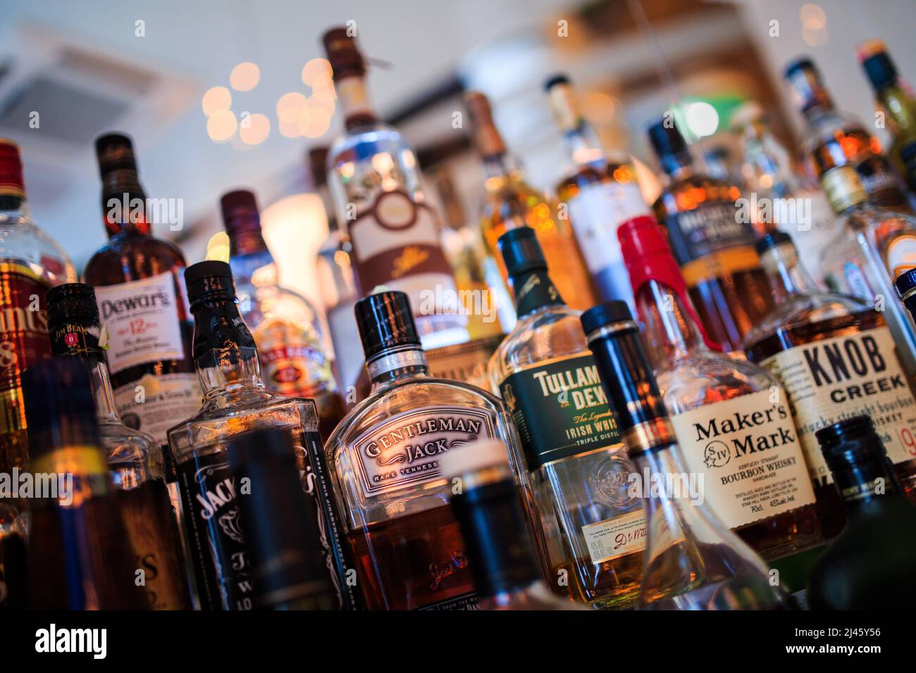 Various bottles of alcoholic beverages on the shelf in the bar Stock