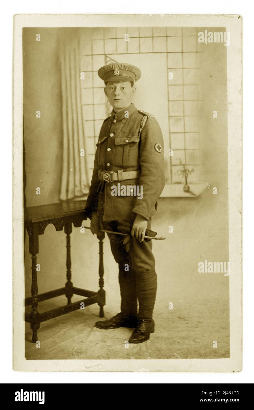 Original WW1 era postcard studio portrait of  First World War Red Cross volunteer or VAD as they were known. He name was Charlie and he looks very weary possibly having seen too much at the Front. He is holding a  riding crop which could mean he worked with horses to bring back the wounded from the trenches.  From Ye Olde Guildhall Studio, 29 St. Thomas St. Winchester 1914-1918. Stock Photo