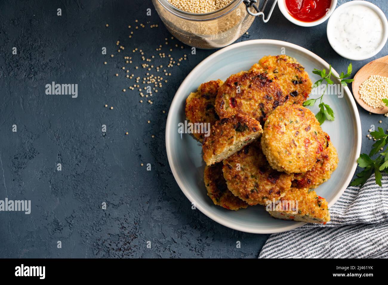 Gluten free vegetarian millet and vegetable burgers served with tomato