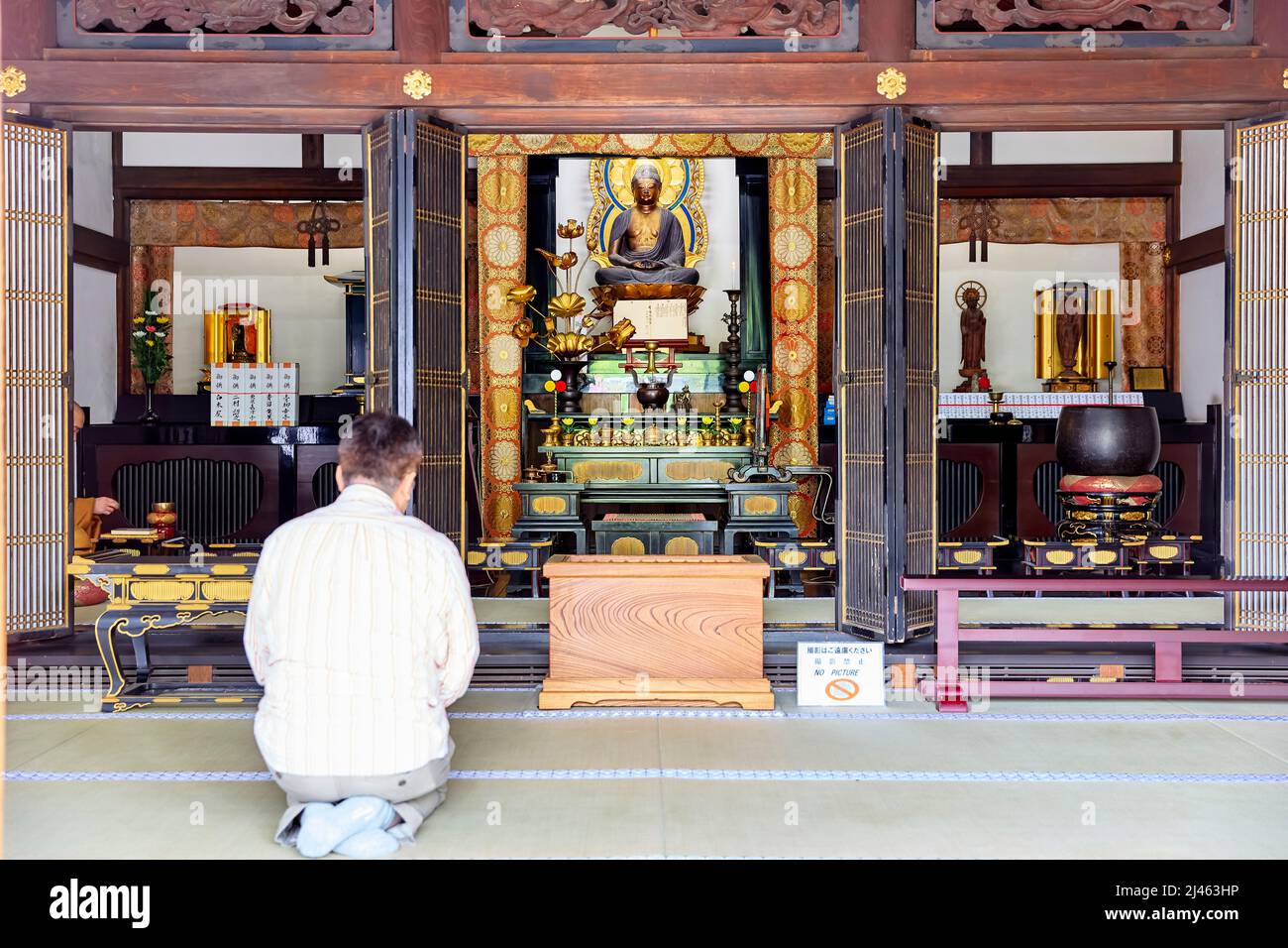 Japan. Tokyo. Ma knelt, praying at Senso ji temple at Asakusa Stock Photo