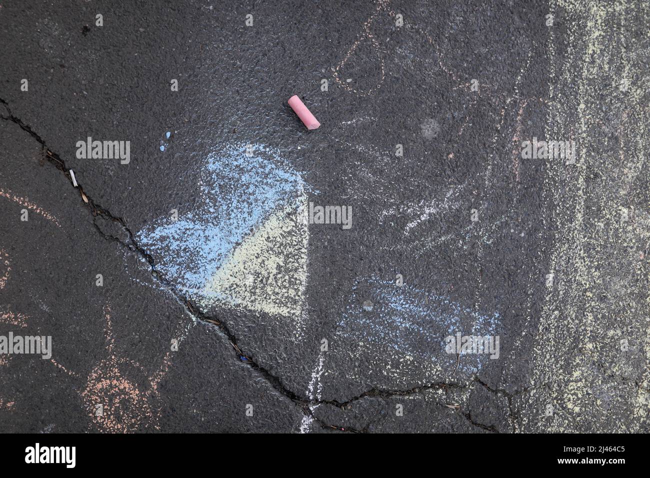 Children drew a Ukrainian flag colour heart with chalk on the sidewalk during an anti war protest in Bucharest, Romania. Stock Photo