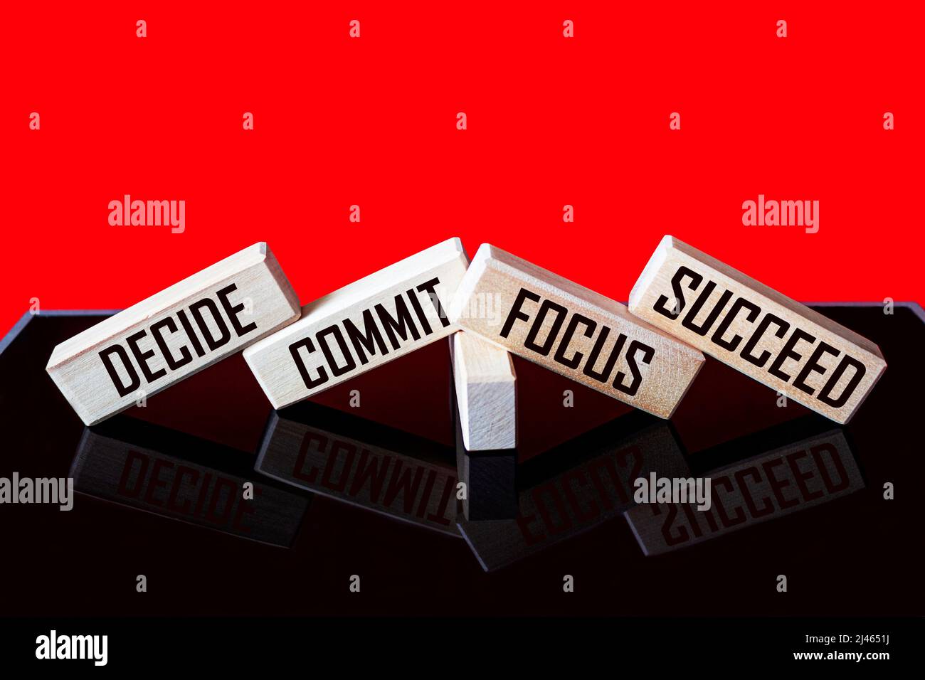 Motivational and inspirational quotes - Decide, commit, focus, succeed on wooden blocks and red black background Stock Photo