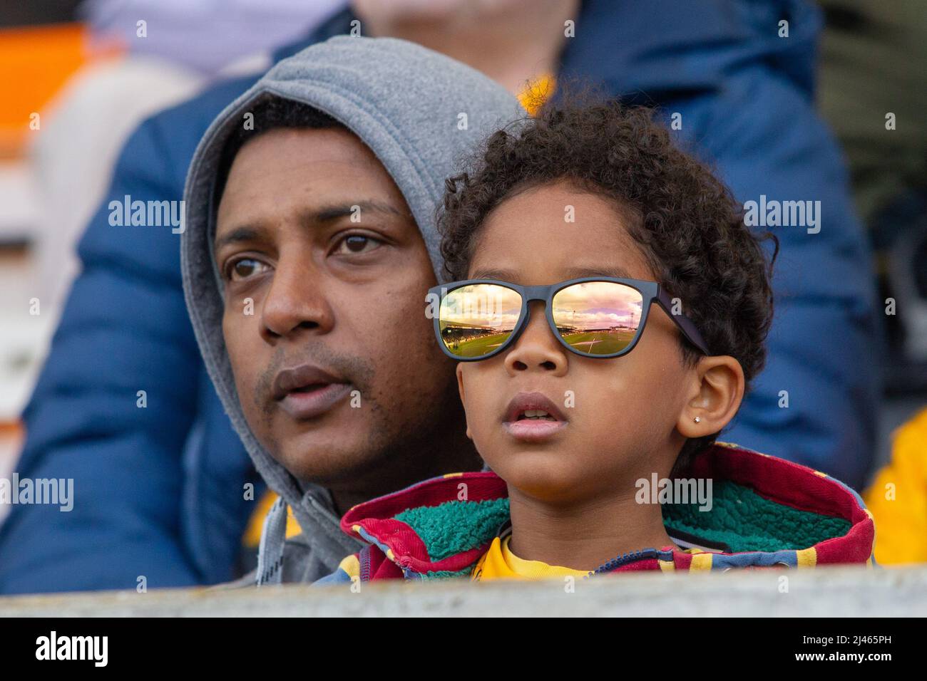 Father and son football spectators watching football match from the stand Stock Photo