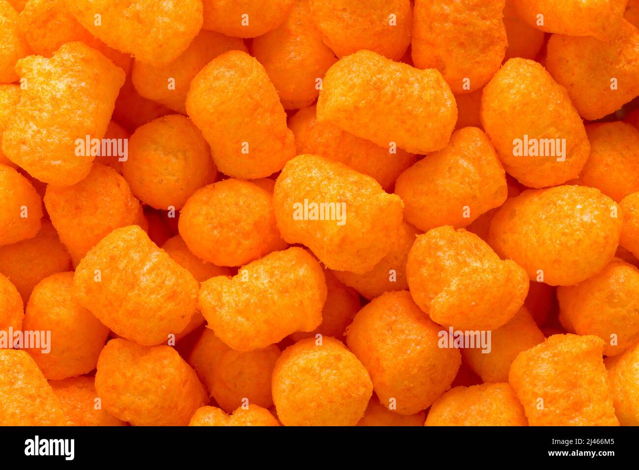Orange Cheese Puff Balls Pile Background Close Up. Stock Photo