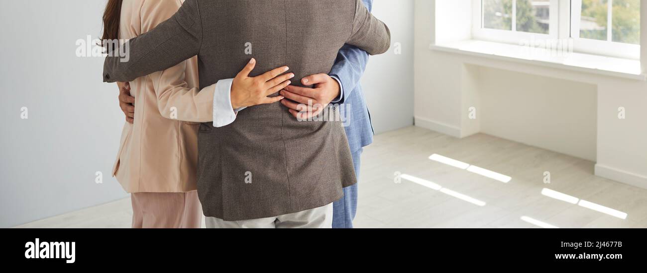 Business colleagues standing in circle hugging together expressing support for each other. Stock Photo