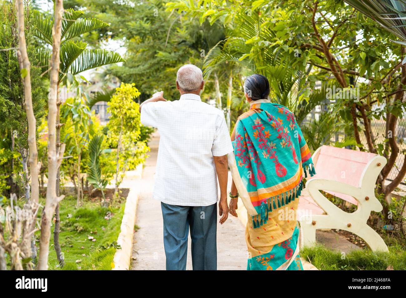 Back view shot of senior couples during morning walk at garden - conept of bonding, relationship and healthy relaxed lifestyle Stock Photo