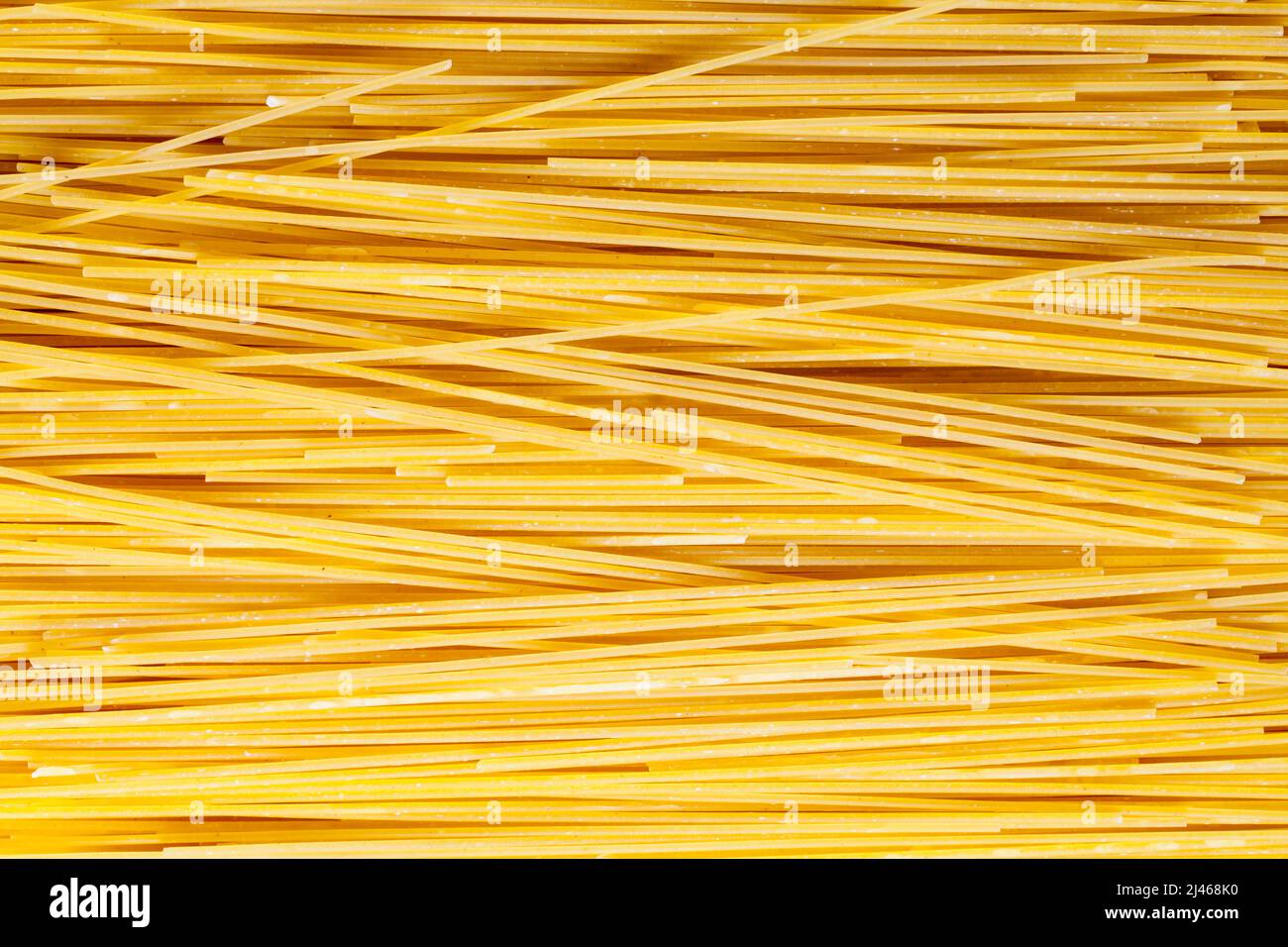 Dry Uncooked Spaghetti Pasta Noodles Background Texture. Stock Photo