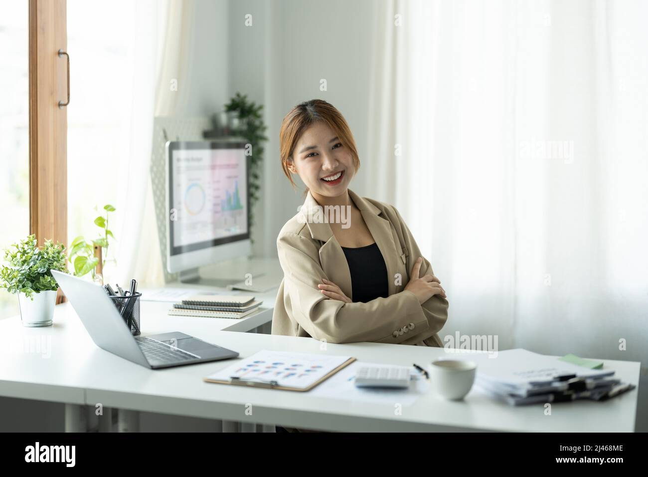 Portrait of young beautiful asian businesswoman looking at camera and ...