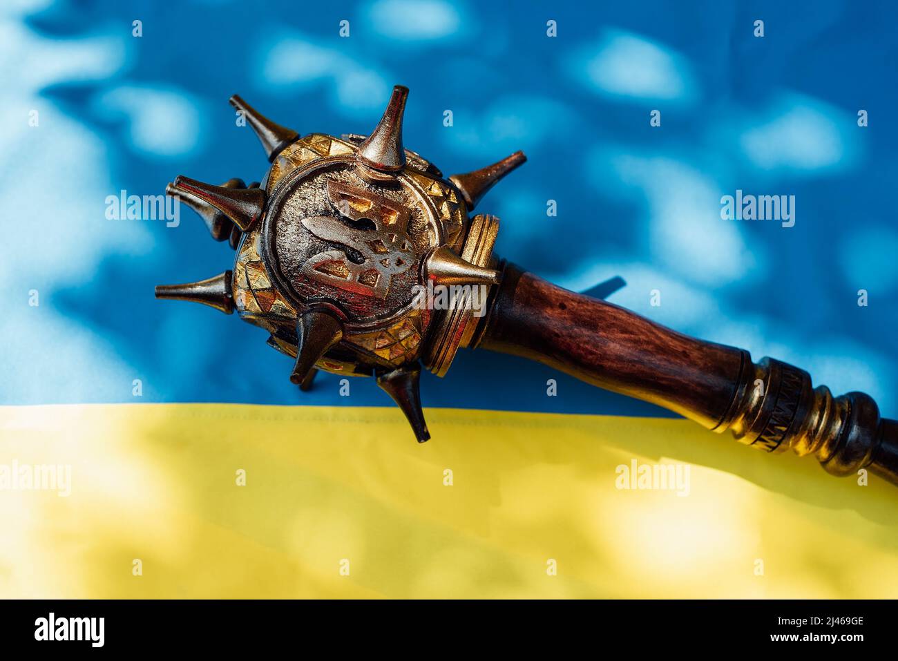 mace with emblem of Ukraine trident on blue and yellow national Flag of ...