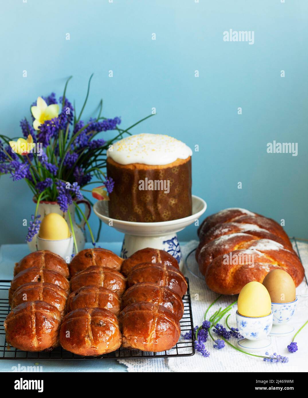 Traditional Easter pastries, cross buns, Easter cake and sweet challah and Easter eggs. Stock Photo