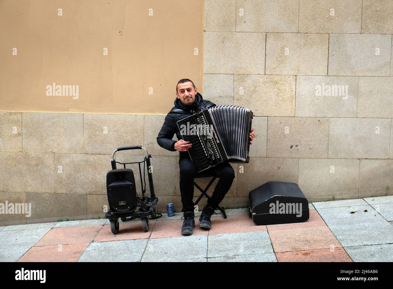 A male street musician, or busker, with an accordion plays in Salamanca, Spain Stock Photo