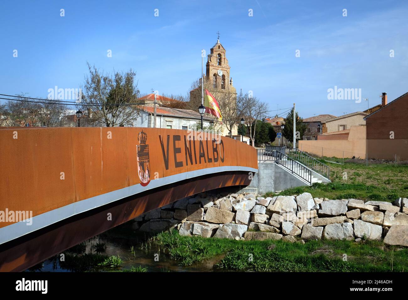 Catholic Church - Parroquia de la Asuncion de Nuestra Senora - in Venialbo, near Zamora, Spain. Seen above the steel footbridge over Arroyo Talanda Stock Photo