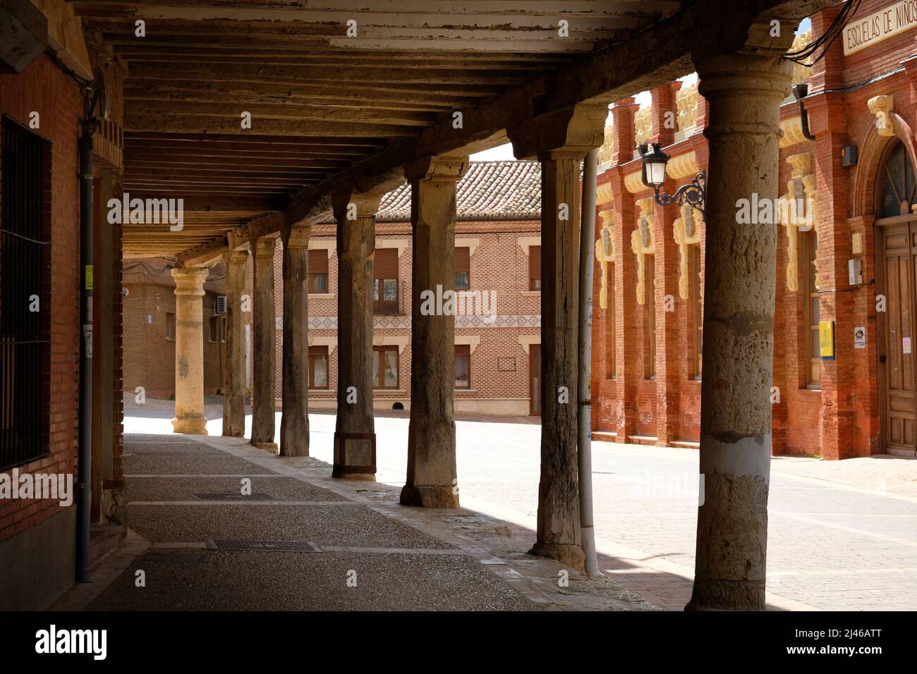 Looking though the pillars of the piered buildings in Plaza Mayor, Becerril de Campos, Spain, towards the town hall Stock Photo