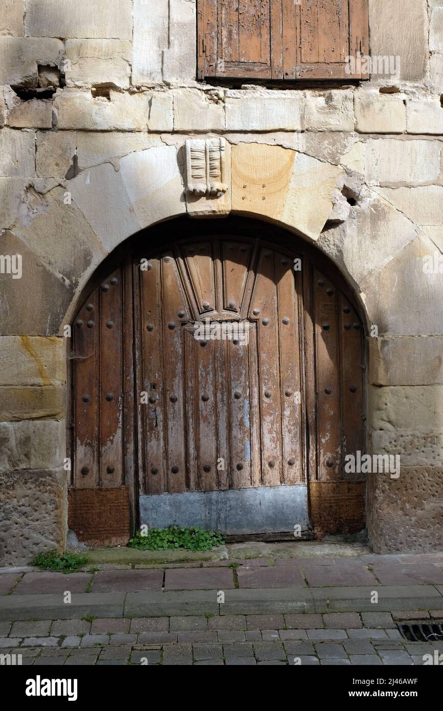 Arched wooden stable door in stone wall, Cartes, Cantabria, Spain Stock Photo