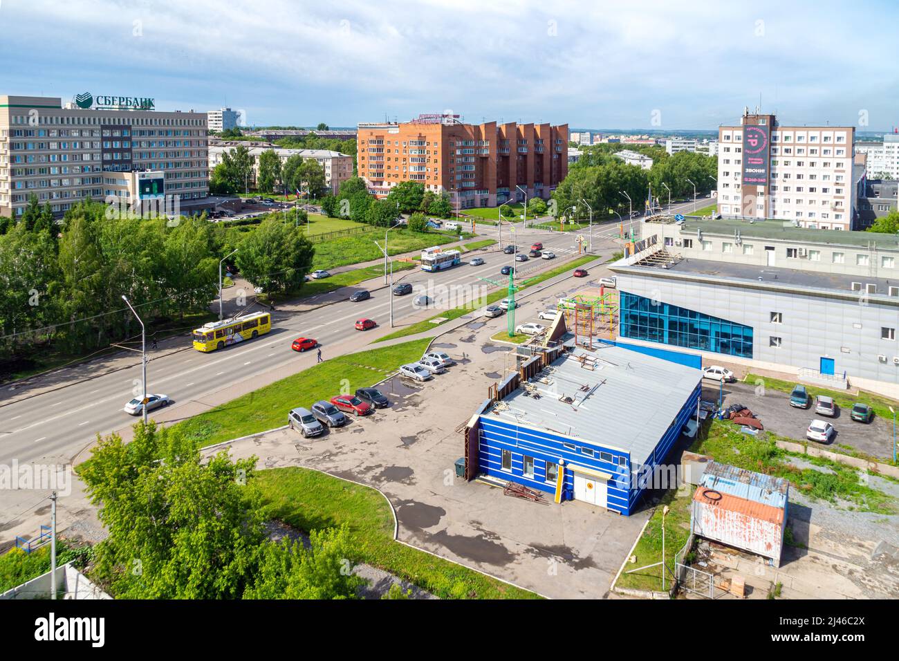 Kemerovo, Russia - 24 june 2021. Urban landscape transport moves in both directions, the building of the savings bank and the mortgage lending agency, Stock Photo