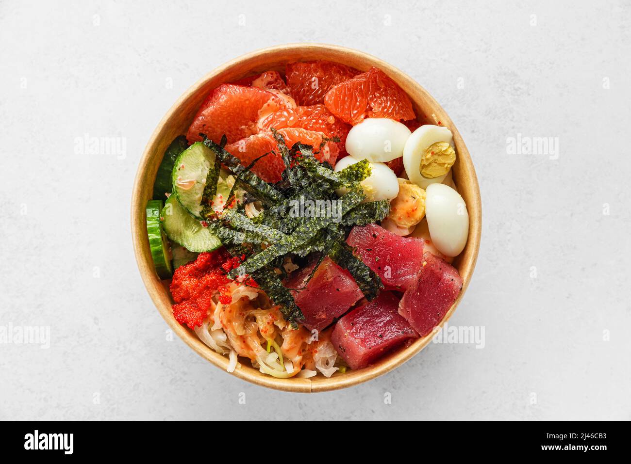 Tuna poke bowl salad in paper package for take away or food delivery on white background. Top view. Healthy food Stock Photo
