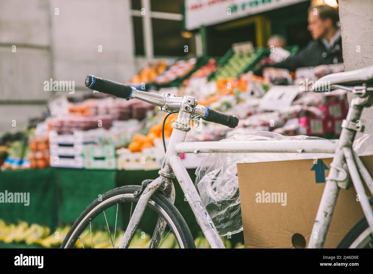 Greater London, London, UK - April 12, 2016: A bicycle can be seen in the foreground of this image, with a fruit and vegetable stall in the background Stock Photo